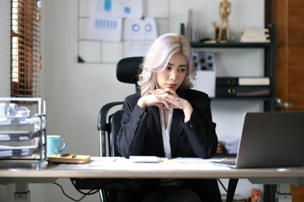 Image of an Asian business woman is stressed, bored, and overthinking from working on a tablet