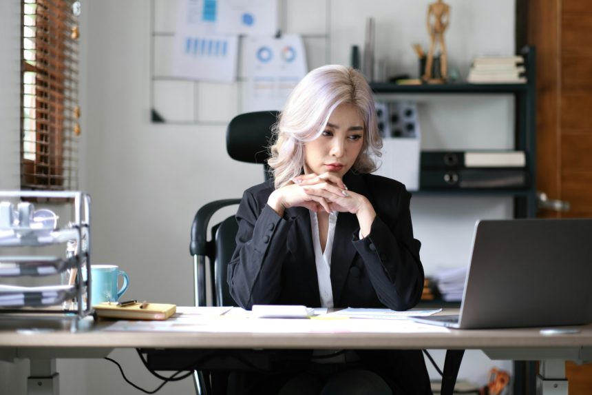 Image of an Asian business woman is stressed, bored, and overthinking from working on a tablet