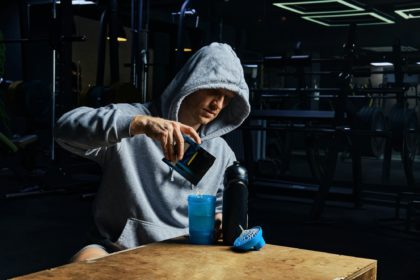 Man pouring energy sports supplement in bottle