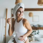 Smiling female doing skin care routine