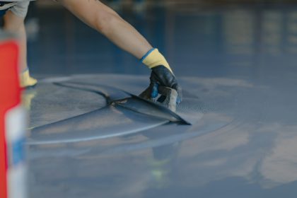 The worker applies gray epoxy resin to the new floor