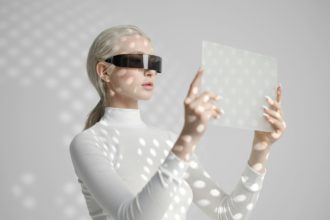 Young woman in glasses holds futuristic gadget